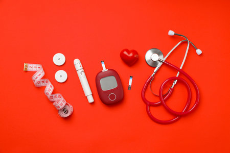 Collection of diabetes tools on a bright red backgroundの写真素材