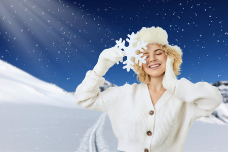 Woman enjoying winter in a snowy landscape with snowflakesの写真素材