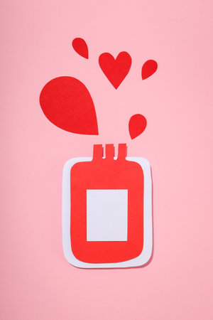 Paper art of a red donation bottle with heart shapesの写真素材