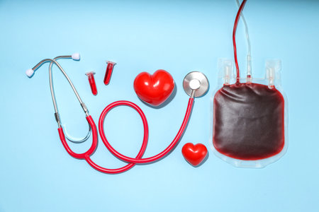 Stethoscope, heart shapes, and blood bag on blue background