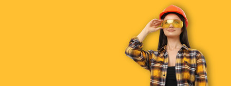 Worker wearing safety glasses and hard hat stands with prideの写真素材