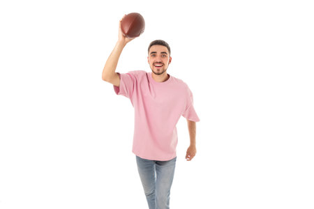 Man smiles while getting ready to throw a football, on white