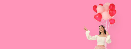 Woman with heart-shaped balloons against a pink backgroundの写真素材