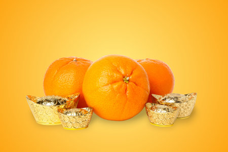 Oranges and gold ingots display festive symbols for the holidayの写真素材