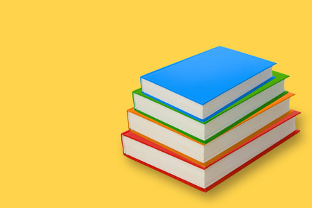 Stack of blank books in different colors on a yellow background
