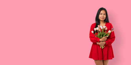 Young woman holds flowers and smiles for Women's Dayの写真素材