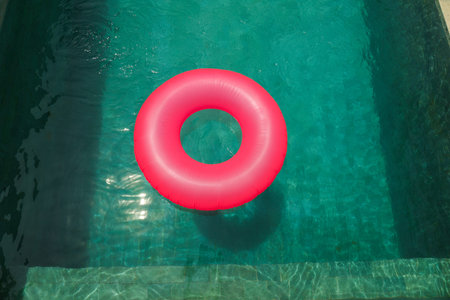 A pink float sits in a clear pool on a sunny day