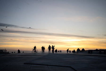 People on the rooftop of Operahuset Oslo in the evening.