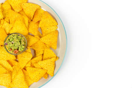 A large plate with crispy nachos and guacamole chips in the center of the dish on a white plate with space for text. Top viewの写真素材