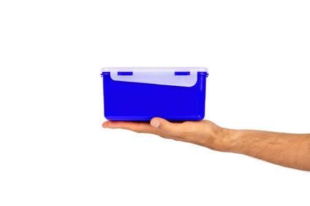 In a man's hand made of eco plastic of the current color, a lunch box for a quick and pleasant lunch, breakfast and dinner. With place for text.の写真素材