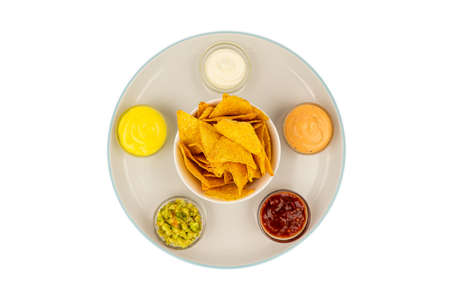 Mexican sauce bowls on a ceramic plate with tortilla chips in the center.の写真素材