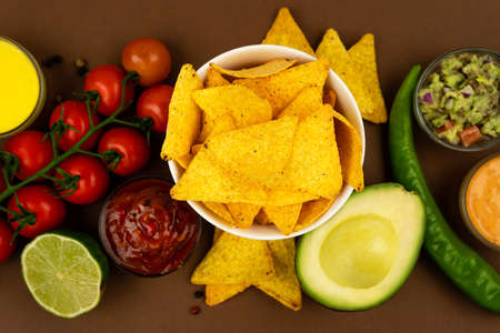 Crispy tortilla nachos chips in a tareoque case with sauces and ingredients.の写真素材