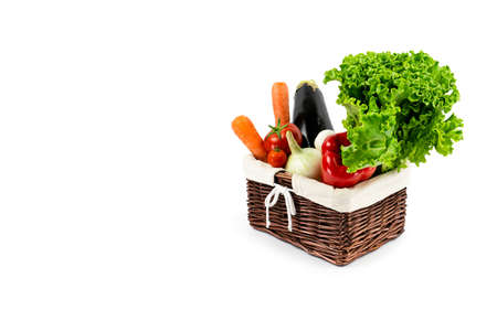A set of fresh ripe vegetables is collected in a wicker basket. Ecology and vegetarianism. Healthy eating. Isolation on a white background.の写真素材