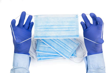 Medical masks in male hands in rubber gloves isolated on white background.