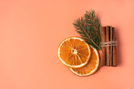 Top view of dry orange slices, cinnamon sticks and pine branches on brown wooden background. Copy spaceの写真素材