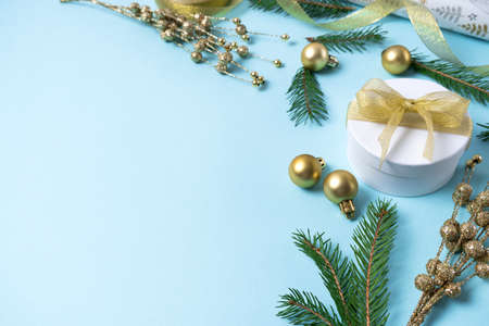 Christmas gold decorations on a light blue background. Holiday and celebration concept for postcard or invitation. Side viewの写真素材