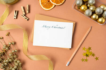 Christmas blank letter with Christmas decoration on beige background. Holiday decorations, gold...