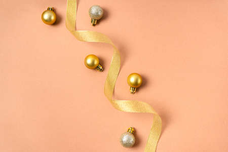 Composition of gold ribbons and gold balls on a beige background. Christmas decorations on the treeの写真素材