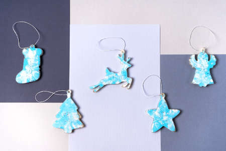 Blue Christmas decorations on a Christmas tree made of epoxy resin on a gray background. Christmas sock, star, deer, angel and tree. Top viewの写真素材