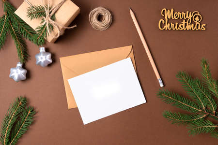 Blank Christmas card on a beige background. Fir branches, holiday decorations. Eco christmasの写真素材