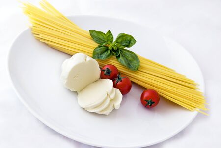 Italian food: spaghetti, mozzarella, cherry tomatoes and basilの写真素材