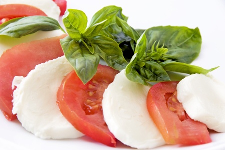 mozzarella, cherry tomatoes and basil om white backgroundの写真素材