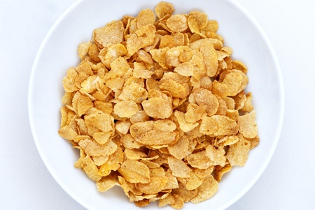 cornflakes in bowl on white background