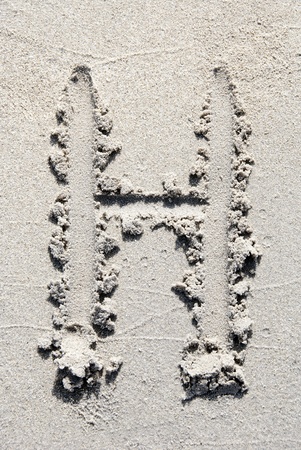 The letter H of the alphabet writing on the sand beachの写真素材