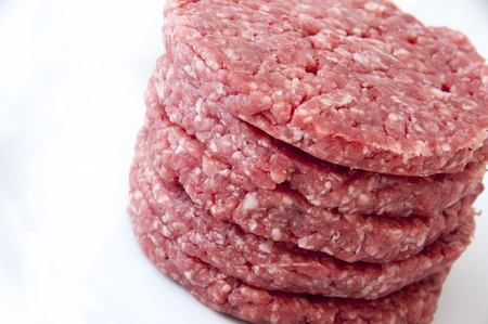 a pile of raw burgers on a white backgroundの写真素材