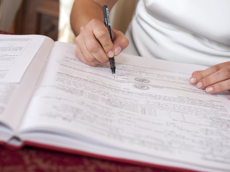 Bride signing wedding contract in church