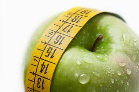 green apple with measure tape on white backgroundの写真素材