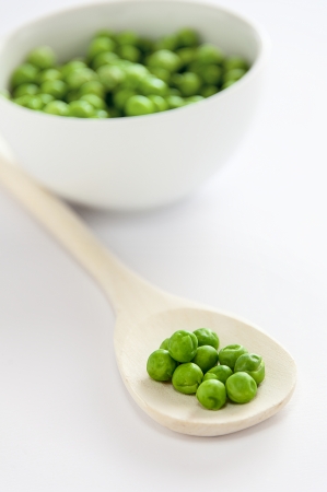 green peas in a wooden spoonの写真素材