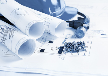 Construction theme with blueprints, nails, hammer and safety helmet