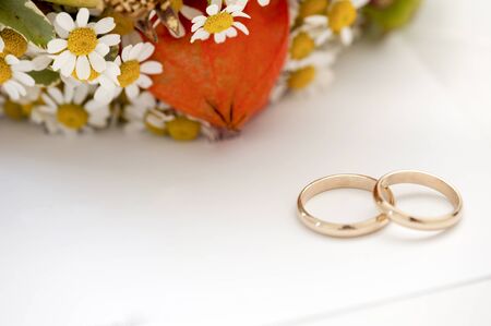 A pair of wedding rings and flowersの写真素材