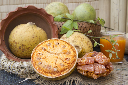 Beal fruits, dried candied fruits and juice in a glass on the background of bamboo. Fresh beal fruit...