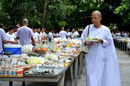 NAKORNNAYOK, THAILAND - JUL 22: Morning alms-offering to Buddhist monks to celebrate in 2013 religious ceremony Asarnha Bucha Day on 22 July 2013 at Temple Watnapapong, Nakornnayok, Thailand.のeditorial素材