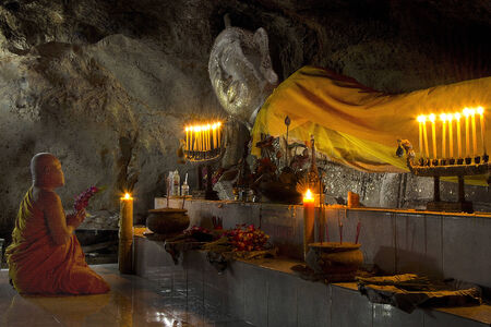 Ratchburi, Thailand - Nov 24  Buddhist monk pray a giant buddha in cave on 24 November 2013 at Tham Chompol, Ratchburi, Thailandのeditorial素材