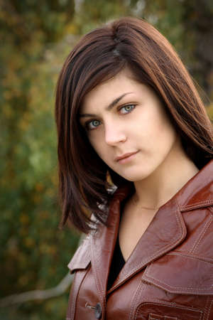 a beautiful young girl is in a brown jacketの写真素材