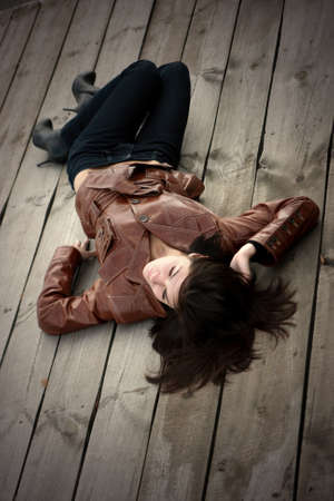 a beautiful young girl is in a brown jacketの写真素材