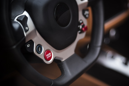 Super Sport Car Interior Detail on Red Engine Start Button on a Wheel