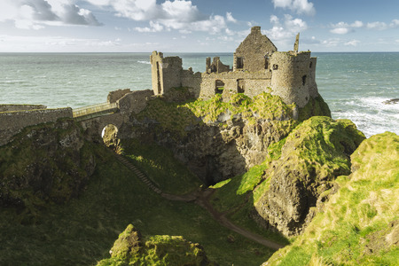 Dunluce Castle, Antrim, Northern Ireland during sunny day with semi cloudy skyのeditorial素材