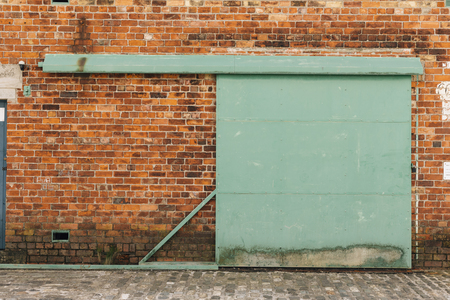 Dark Brick Wall with Metal Gate Doorの写真素材