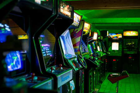 Prague, Czech Republic - Oct 25, 2017: Dark room full of old vintage classic arcade gamesのeditorial素材