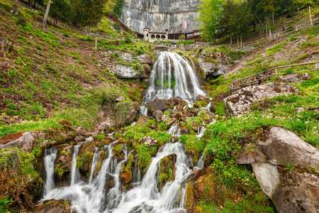 St. Beatus Cave and waterfalls above Thunersee, Sundlauenen, Switzerland. Falls are running down the mountain with a green grass and long exposure of waterfallsの写真素材