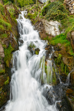 St. Beatus Cave and waterfalls above Thunersee, Sundlauenen, Switzerland. Falls are running down the mountain with a green grass and long exposure of waterfallsの写真素材