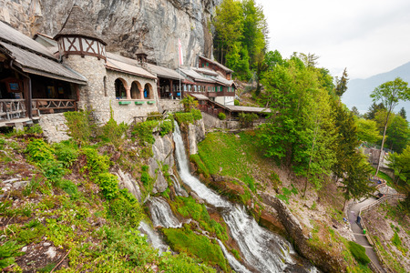 St. Beatus Cave and waterfalls above Thunersee, Sundlauenen, Switzerland. Falls are running down the mountain with a green grass and long exposure of waterfallsの写真素材