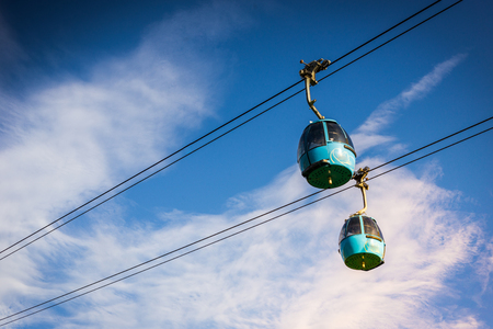 Aerial Tram Cable Car going up, during sunset, with beautiful high mountains in the background in Alpe di Siusi, Dolomites, Italyの写真素材