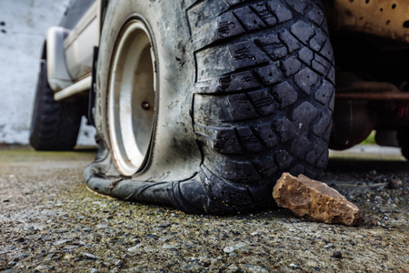 Damaged flat offroad tire on a roadの写真素材
