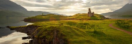 Ardvreck Castle surrounded by water and lit by sunset, located near Lairg, Scotland, UKの写真素材