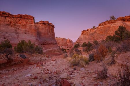 Rocks and Mountains along a trail to Tunnel Slot during sunny day with blue sky in Escalante...